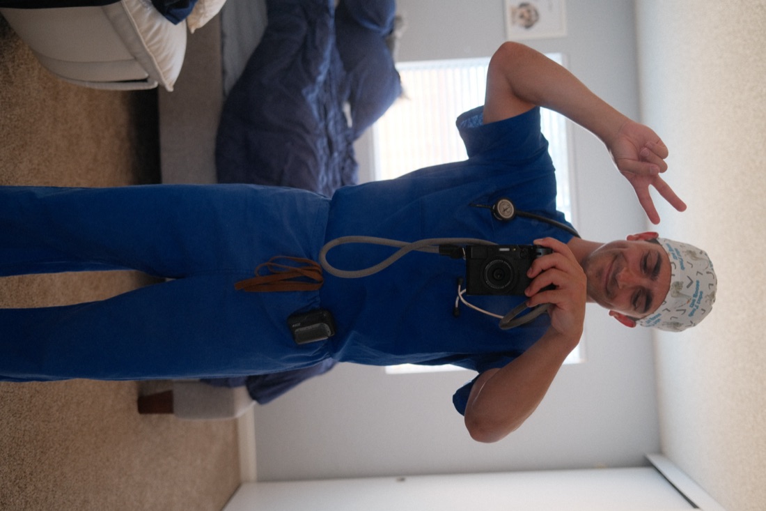 Shaun in scrubs holding a camera